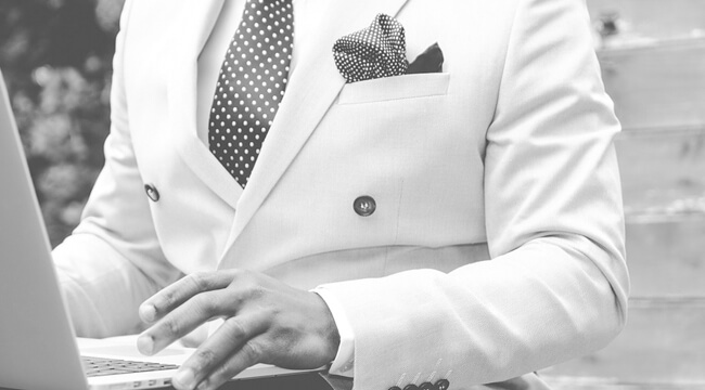 A man with suit working on laptop