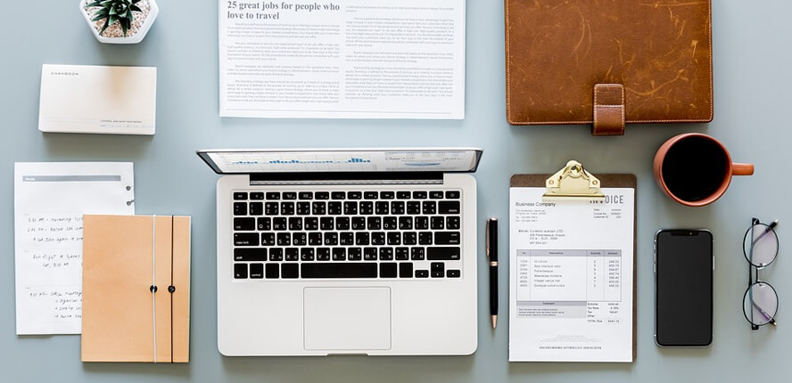 Laptop, paperwork, and phone on table
